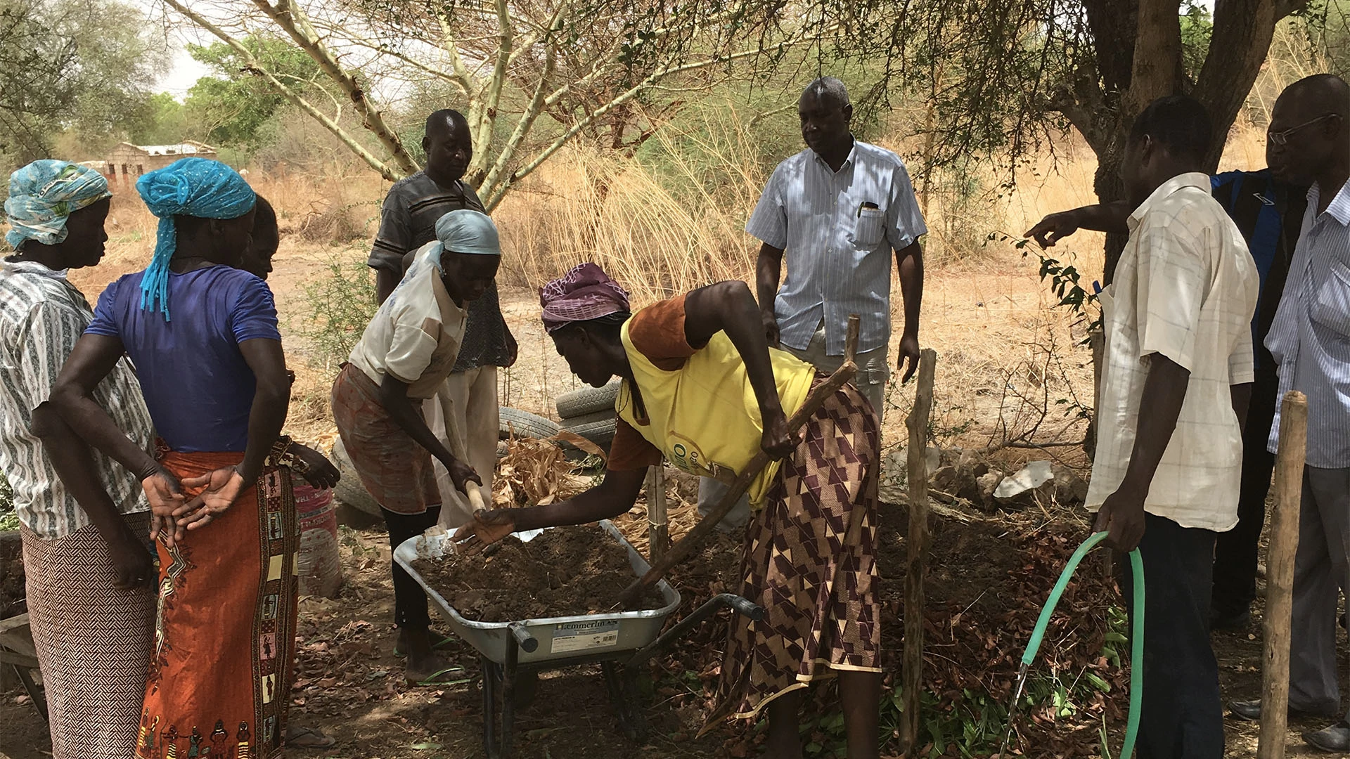 A group of people in an African village digging new land to build a church